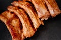 fried with spices pork ribs in a glass baking sheet on a stone black background Royalty Free Stock Photo