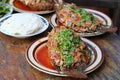 Fried spicy fish with variety Thai food on wooden table