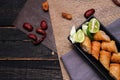 Fried spring rolls in a black plate served with tamarind sauce on a black wooden table Royalty Free Stock Photo