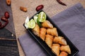 Fried spring rolls in a black plate served with tamarind sauce on a black wooden table Royalty Free Stock Photo