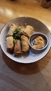 Fried spring rolls in a plate on a wooden table, top view Royalty Free Stock Photo