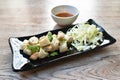 Fried squid egg or gonad with chop fresh cabbage on plate dipping spicy and sour sauce