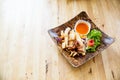 fried squids in wood plate.Steamed squid fried with salty sauce Thai food. Royalty Free Stock Photo