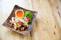 Fried squids in wood plate.Steamed squid fried with salty sauce Thai food. Royalty Free Stock Photo