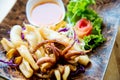 Fried squids in wood plate.Steamed squid fried with salty sauce Thai food. Royalty Free Stock Photo