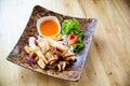 Fried squids in wood plate.Steamed squid fried with salty sauce Thai food. Royalty Free Stock Photo