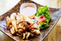 Fried squids in wood plate.Steamed squid fried with salty sauce Thai food. Royalty Free Stock Photo