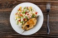 Fried steak from salmon with vegetable mix in plate, fork on wooden table. Top view Royalty Free Stock Photo