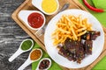 Fried sticky ribs sprinkled with green onion with french fries Royalty Free Stock Photo