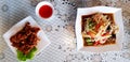 Fried sun dried pork with green cabbage leaves, spicy Thai papaya salad in white dish and  small bowl of hot chili sauce Royalty Free Stock Photo