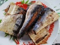 Fried sun dried salted mackerel fish on vintage retro dish for serve lunch meal on table in countryside rural house at Phatalung