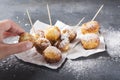 Fried sweet dough balls with sweet powdered sugar.Woman taking cheese balls