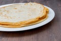 Fried tasty thin slapjack on wooden background