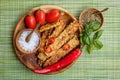 Fried tempeh, chili peppers, fresh cherry tomatoes, basil leaves, mix of herbs and sea salt in wooden pots with wooden spoons on a Royalty Free Stock Photo