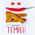 Fried tempeh decorated with chilly smile. YUMMY TEMPEH caption. Top view. Royalty Free Stock Photo