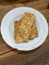 Fried tempeh on a plate on a wooden table Royalty Free Stock Photo