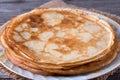 Fried thin pancakes on a plate on a wooden table Royalty Free Stock Photo