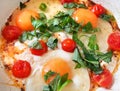 Fried three eggs with ripe red cherry tomato and green basil leaves. Royalty Free Stock Photo