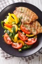 Fried tilapia fillet, fresh salad with pepper and tomato close-up. vertical top view Royalty Free Stock Photo