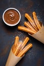 Fried traditional churro sticks with sugar powder cinnamon and bowl of chocolate dip