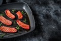 Fried Turkish Sucuk meat sausage on a grill skillet. Black background. Top view. Copy space