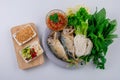 Fried two short bodied mackerel fishes and vegetable on white plate on black table