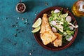 Fried white fish fillet and cucumber and radish salad. Royalty Free Stock Photo