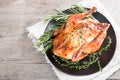 Fried whole chicken with herbs over natural wood background. who