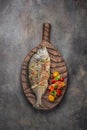 Fried whole Sea bream fish with vegetables on cutting board, copy space Royalty Free Stock Photo