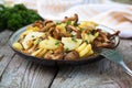 Fried young potatoes with chanterelles mushrooms in bowl on old Royalty Free Stock Photo