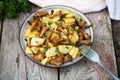 Fried young potatoes with chanterelles mushrooms in bowl on old Royalty Free Stock Photo