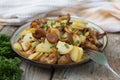 Fried young potatoes with chanterelles mushrooms in bowl on old Royalty Free Stock Photo