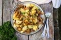 Fried young potatoes with chanterelles mushrooms in bowl on old Royalty Free Stock Photo