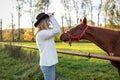 Cowgirl playing with her young horse at farm Royalty Free Stock Photo