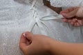 A friend of the bride ties a bow on her wedding dress Royalty Free Stock Photo