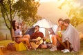 Friend on camping listening boy playing guitar Royalty Free Stock Photo