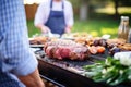 friend grilling ribeye steak at garden party