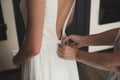 A friend helps to dress the bride& x27;s wedding dress. Royalty Free Stock Photo