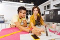 Young dressmaker frowning while cheerful tailor giving her pieces of advice