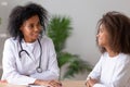 Friendly african american female doctor talking to teen girl patient