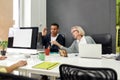 Friendly aged woman, female worker training or teaching new employee, Young man listening to his older colleague while