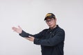 A friendly asian male security guard points to the left with both hands. Doing and handling a presentation. Isolated on a white Royalty Free Stock Photo