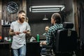 Friendly barber smiling while talking to client