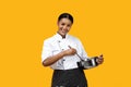 Friendly black female chef stirring stainless steel pot and smiling at camera