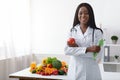 Friendly black woman dietician with apple and tape Royalty Free Stock Photo