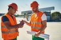 Friendly builder talking and his colleague making notes