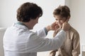Friendly caring male pediatrician examining kid, touching lymph nodes Royalty Free Stock Photo