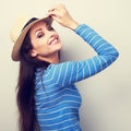 Friendly casual woman in blue top and straw hat posing and looking happy. Toned closeup portrait