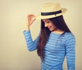 Friendly casual woman in blue top and straw hat posing and looking happy