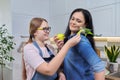 Friendly cheerful family, portrait of mom and teenage daughter, with green parrot